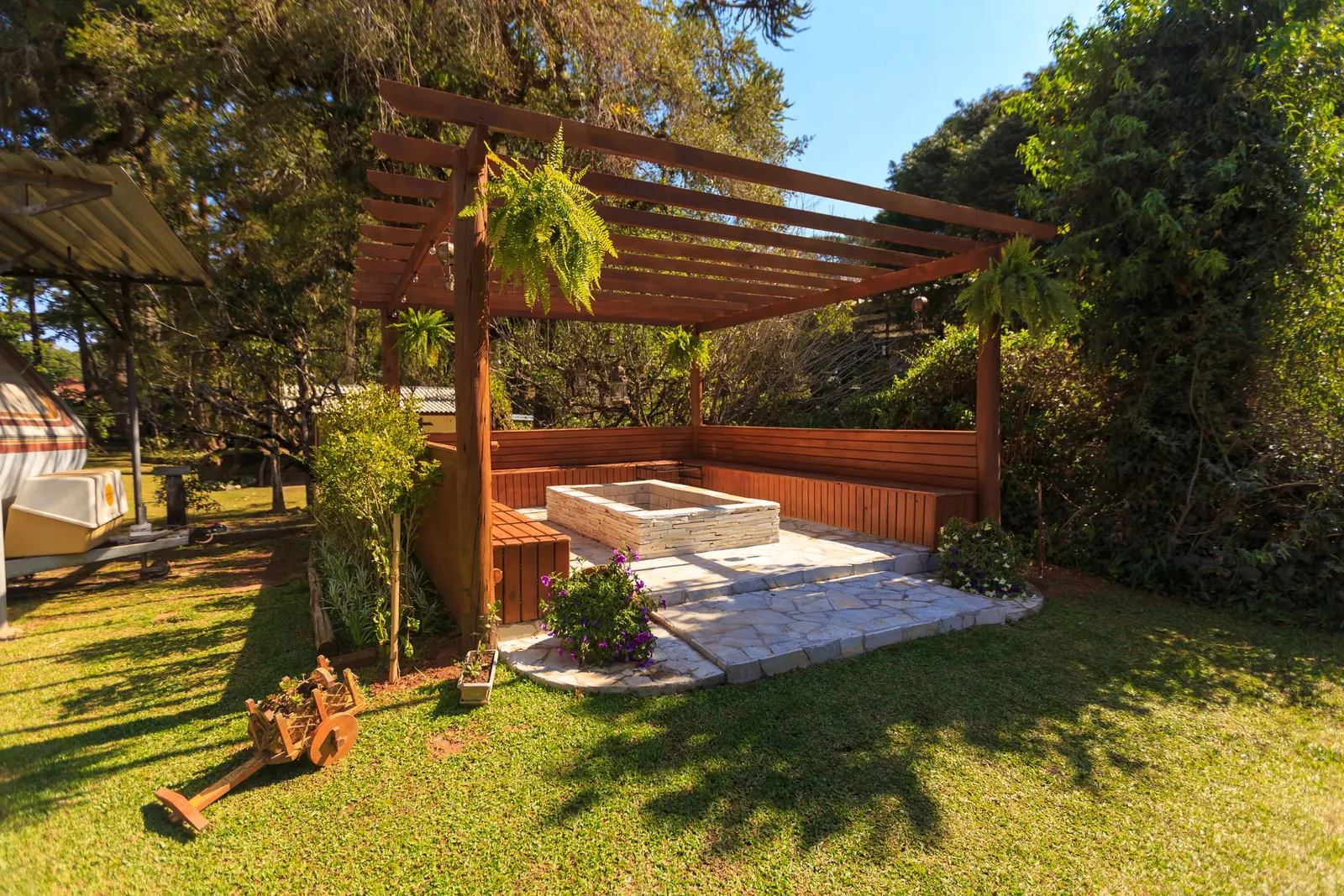 Houten pergola met zitplek in een zonnige tuin